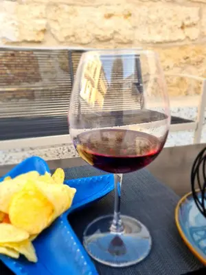 a glass of red wine sitting on a table at Azzurra Home in Terrasini