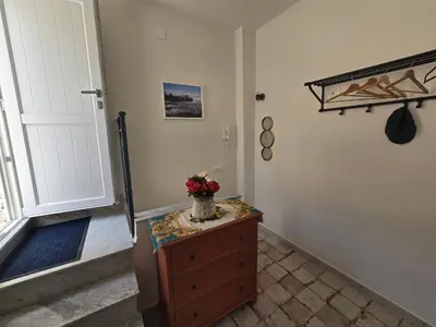 a room with a dresser with a vase of flowers on it at Azzurra Home in Terrasini