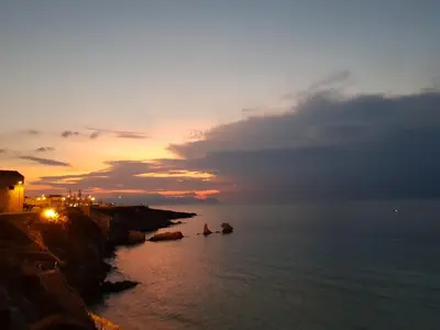 a sunset over the ocean with boats in the water at Azzurra Home in Terrasini
