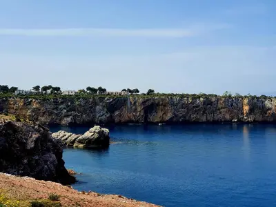 a large body of water next to a rocky cliff at Azzurra Home in Terrasini