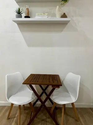 a wooden table with two white chairs and a shelf at Aloha in Palermo