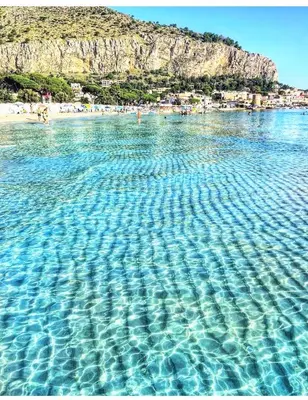 a large body of water with people on a beach at CasaRò (delizioso alloggio a Mondello) in Palermo