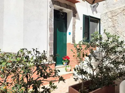 a green door on a house with flowers on the steps at CasaRò (delizioso alloggio a Mondello) in Palermo