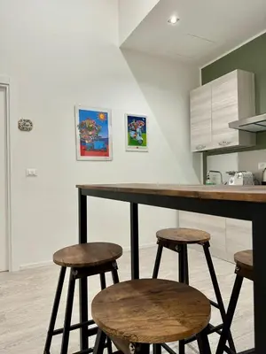 a kitchen with a counter with stools in it at Casa Politeama Florio - Palermo centro in Palermo