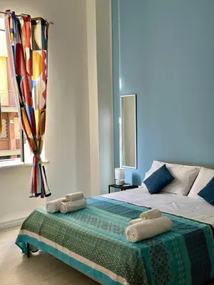a bedroom with a bed with two towels on it at Casa Politeama Florio - Palermo centro in Palermo