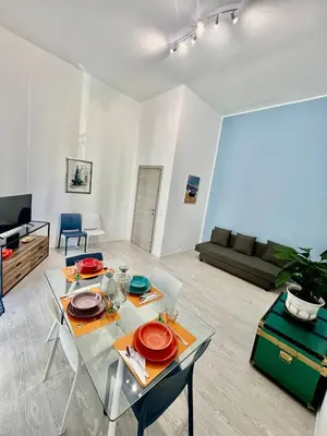 a living room with a table and chairs and a couch at Casa Politeama Florio - Palermo centro in Palermo