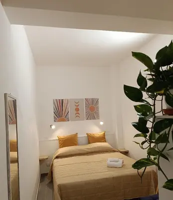 a bedroom with a bed with a mirror and a plant at La Casetta di Nino in Castellammare del Golfo