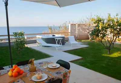 a table and chairs on a patio with a grill at Villa Laura in Balestrate