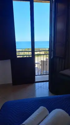 a bedroom with a bed and a view of the ocean at Alykè Appartamenti Vacanze Macari in Macari