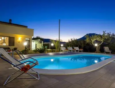a swimming pool with a chair next to a house at Villa Donna Franca con piscina privata in Castellammare del Golfo