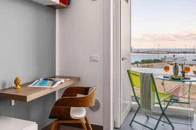 a room with a table and chairs and a balcony at FronteMare in Palermo