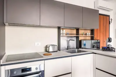 a kitchen with white cabinets and stainless steel appliances at FronteMare in Palermo