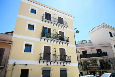 a yellow building with balconies on a street at Politeama Theater Apartments in Palermo