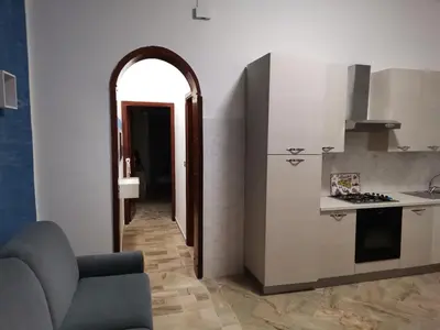 a kitchen with an archway leading into a living room at La Vie Est Belle in Balestrate