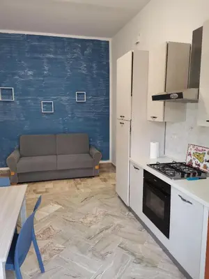 a kitchen with a couch and a stove top oven at La Vie Est Belle in Balestrate