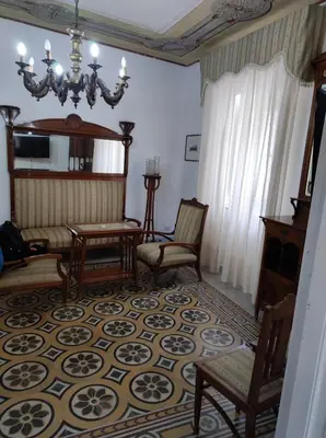 a living room with chairs and a chandelier at Casa Giannina in Palermo
