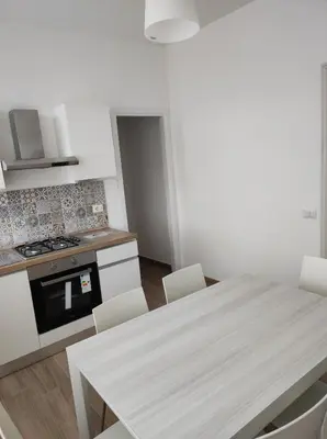 a kitchen with a table with chairs and a stove at Casa Giannina in Palermo
