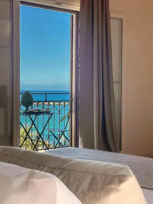 a bedroom with a window with a view of the ocean at Castellano suites in Castellammare del Golfo