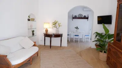 a living room with a white couch and a table at Castellano suites in Castellammare del Golfo