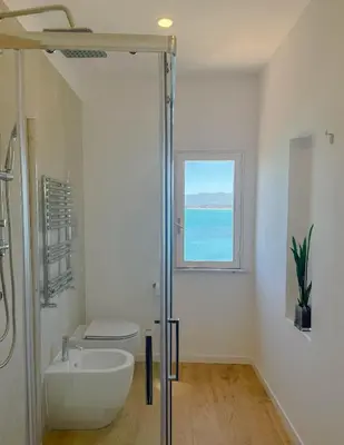 a bathroom with a sink and a toilet and a window at Castellano suites in Castellammare del Golfo