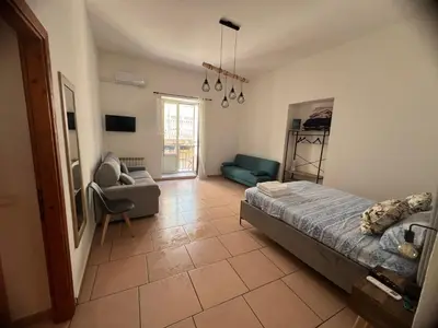 a bedroom with a bed and a couch and a chair at GRETA'S APARTMENT DISCESA DELLE CAPRE in Palermo