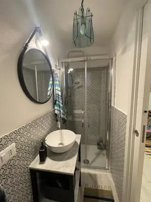 a bathroom with a sink and a shower with a mirror at Studio 29 in Palermo