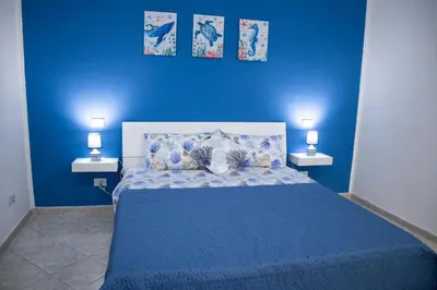 a blue bedroom with a bed with a blue wall at L'ancora casa vacanze in Palermo