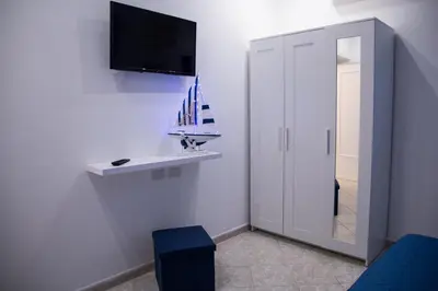 a bathroom with a sink and a tv on a wall at L'ancora casa vacanze in Palermo