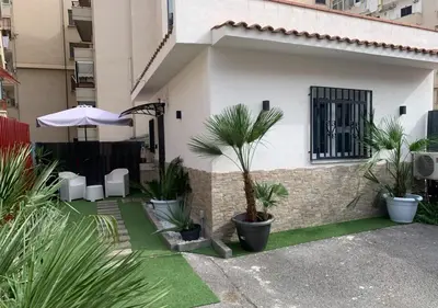 a house with a courtyard with plants and an umbrella at Zisa Private House in Palermo