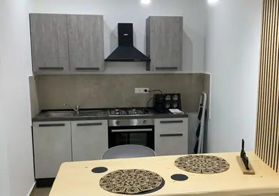 a small kitchen with a stove and a table at Zisa Private House in Palermo