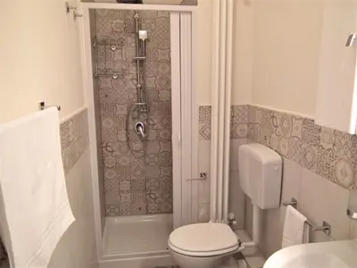 a bathroom with a shower with a toilet and a sink at A Casa di Giovi in Palermo