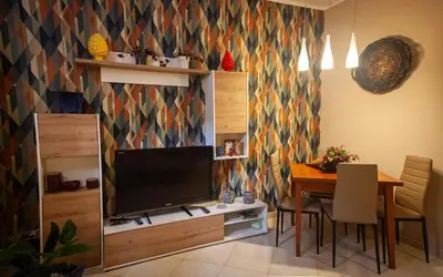 a living room with a television and a dining room table at vivà house in Palermo