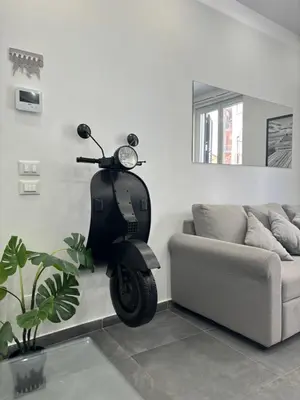 a scooter parked in a living room next to a couch at Modern House Orleans in Palermo