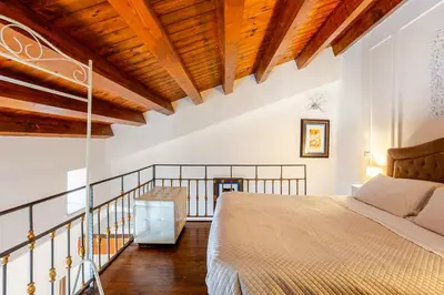 a bedroom with a bed and a wooden ceiling at Dimora degli Scalzi - Dive into Palermo's History in Palermo