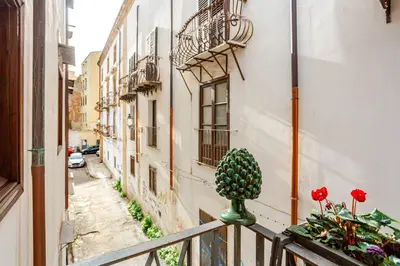 a balcony with a potted plant on a railing at Dimora degli Scalzi - Dive into Palermo's History in Palermo