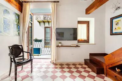 a living room with a tv and a chair in a room at Dimora degli Scalzi - Dive into Palermo's History in Palermo