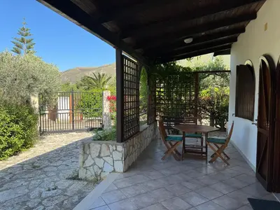 a patio with a table and chairs on a house at Villa Il Giardino di Rosa- 5 Min from the sea-Fraginesi in Castellammare del Golfo