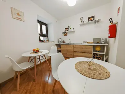 a kitchen and dining room with a white table and chairs at SANT'ELIGIO APARTMENTS & ROOMS in Palermo