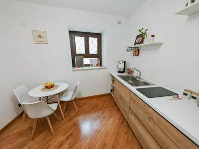 a kitchen with a sink and a table with chairs at SANT'ELIGIO APARTMENTS & ROOMS in Palermo