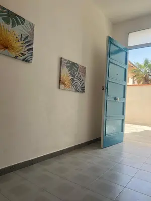 a room with a blue door and two pictures on the wall at Miramare in Balestrate