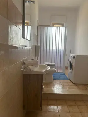 a bathroom with a sink and a washing machine at Miramare in Balestrate