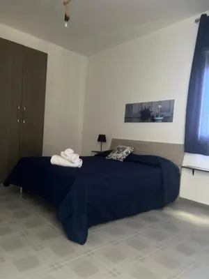 a bedroom with a blue bed with two towels on it at Miramare in Balestrate