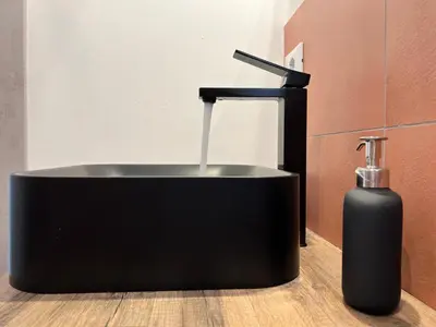 a black bath tub with a bottle of soap at M'AMA apartment 1 in Ficarazzi