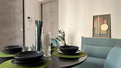 a dining room table with black plates and chairs at M'AMA apartment 1 in Ficarazzi