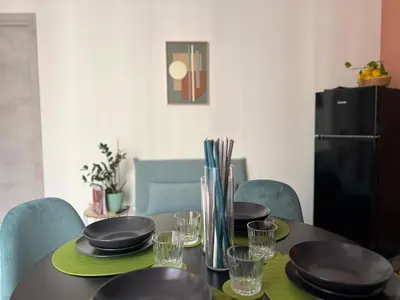 a dining room table with plates and glasses on it at M'AMA apartment 1 in Ficarazzi