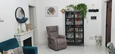 a living room with a chair and a mirror at Casa Basile in Palermo