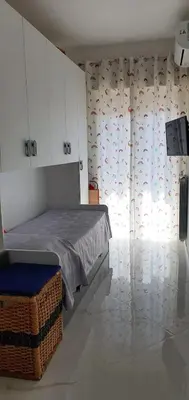 a bedroom with a bed and a window with curtains at Casa Basile in Palermo