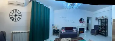 a living room with green curtains and a chair and a clock at Casa Basile in Palermo