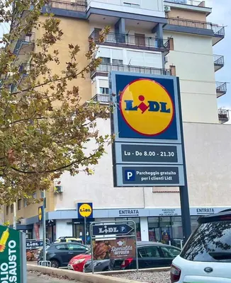 a sign in front of a building with cars parked at Casa Basile in Palermo