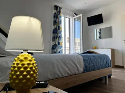 a bedroom with a bed with a lamp on a table at M'AMA apartment 2 in Ficarazzi